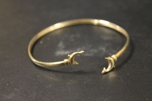 A YELLOW METAL BANGLE WITH DOLPHIN DETAIL, STAMPED 9 TO ONE COLLAR, APPROX WEIGHT 2.8G