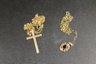 A 9CT CROSS ON AN UNMARKED YELLOW METAL CHAIN TOGETHER WITH A 9CT GARNET SET PENDANT ON A CHAIN