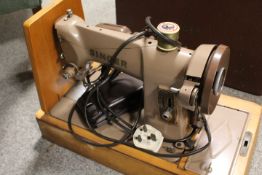 A VINTAGE CASED ELECTRIC SINGER SEWING MACHINE (UNCHECKED)
