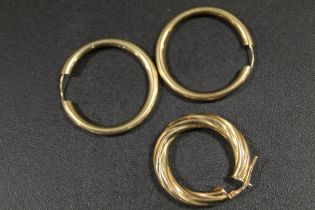 A PAIR OF YELLOW METAL HOOP EARRINGS TOGETHER WITH A SINGLE EARRING MARKED 9CT GOLD