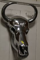 A LARGE CHROME EFFECT CAST METAL MODEL OF A COW SKULL