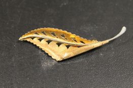 A BROOCH IN THE FORM OF A LEAF STAMPED 750 APPROX 4.5G