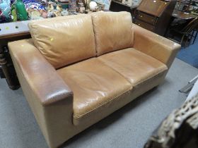 A TAN LEATHER TWO SEATER SOFA