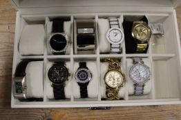 A QUANTITY OF DESIGNER STYLE WATCHES IN A DISPLAY CASE
