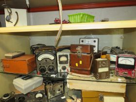 A SHELF CONTAINING VARIOUS AVO METERS AND OTHER ELECTRCIAL TESTERS