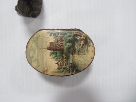 AN ANTIQUE PAPIER MACHE SNUFF WITH SCENIC IMAGE TO HINGED LID TOGETHER WITH A MODERN SMALL FIGURE OF