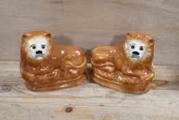 A PAIR OF VICTORIAN STAFFORDSHIRE STYLE CERAMIC LION FIGURES