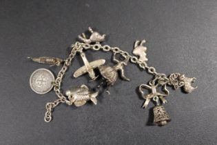 A SILVER CHARM BRACELET WITH ATTACHED CHARMS A/F