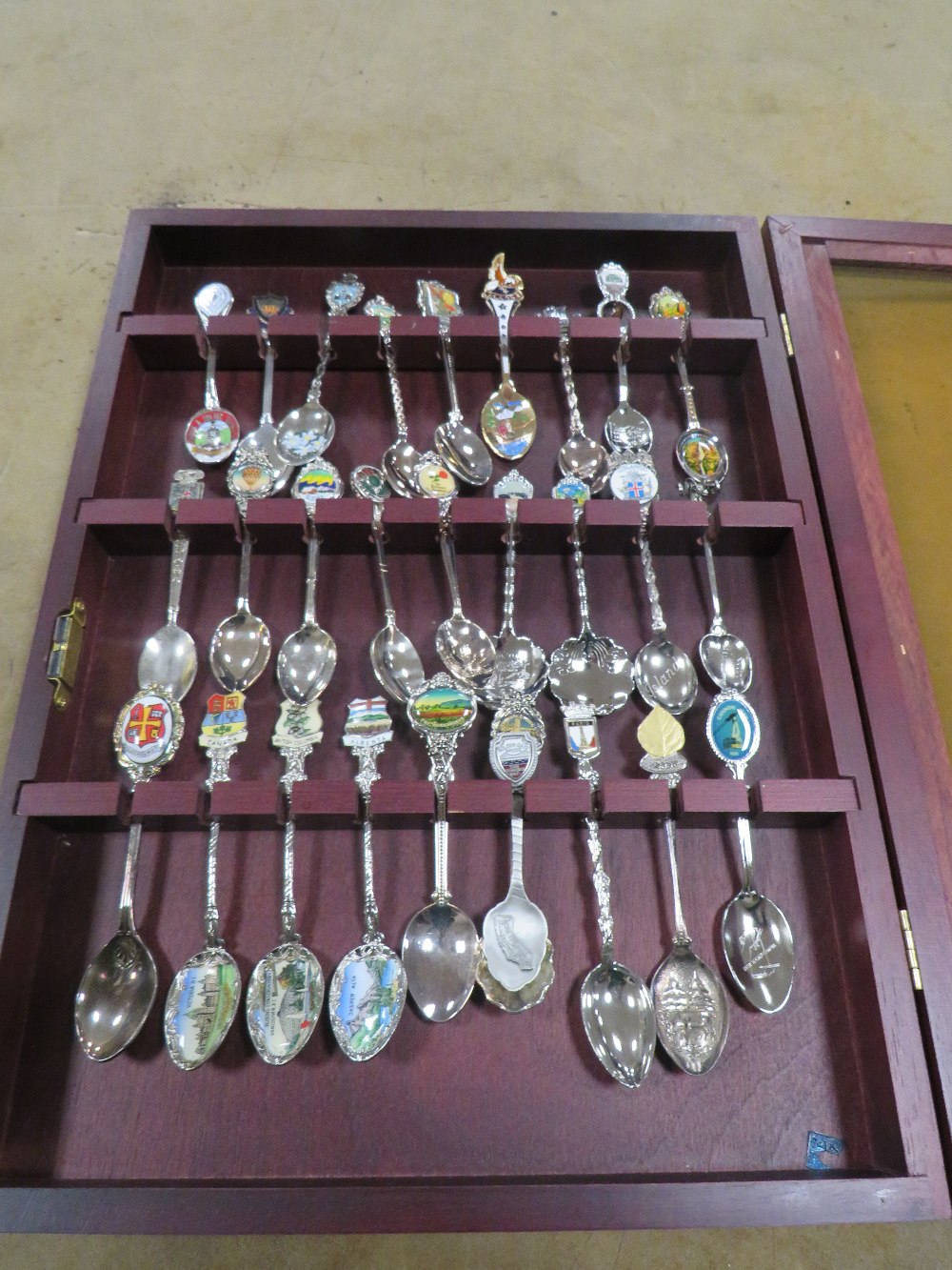 A DISPLAY CASE CONTAINING COLLECTORS SPOONS