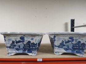 A PAIR OF BLUE/WHITE WILLOW PATTERN PLANTERS