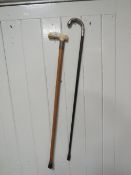 A HALLMARKED SILVER TOPPED WALKING CANE TOGETHER WITH A HALLMARKED SILVER BANDED BONE HANDLED