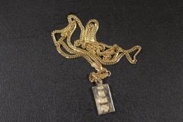 A HALLMARKED 9CT GOLD INGOT STYLE PENDANT FOR THE YEAR 2000 ON A 375 STAMPED FLAT LINK CHAIN