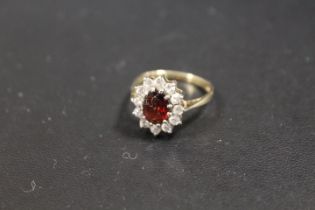 A HALLMARKED 9CT GOLD DRESS RING SET WITH A GARNET STYLE STONE