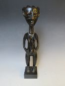 A CARVED AFRICAN TRIBAL STATUE, depicting a standing female, on later plinth, H 34 cm (excl.