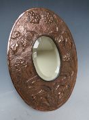 AN ART NOUVEAU COPPER OVAL MIRROR, with embellished stylised floral detail, 32.5 x 23.5 cm Condition