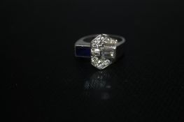 A SAPPHIRE AND DIAMOND 'BUCKLE RING, set with a baguette cut diamond of an estimate half a carat