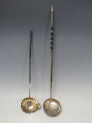 TWO GEORGIAN SILVER TODDY LADLES , with ebonised handles, overall L 43 cm and 34 cm (2)