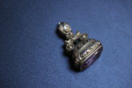 A GILT METAL FOB SEAL WITH CARVED INTAGLIO AMETHYST OF A WINGED MAN USING A POSHER ENTITLED '