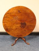 A GEORGIAN MAHOGANY TILT-TOP PEDESTAL TABLE, the one piece top raised on a tapered column and tripod