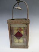 A DECORATIVE ARTS AND CRAFTS STYLE COPPER HANGING LANTERN, with glazed coloured and leaded panels,