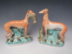 A PAIR OF LARGE STAFFORDSHIRE STANDING GREYHOUNDS, one with a hare in his mouth, the other at
