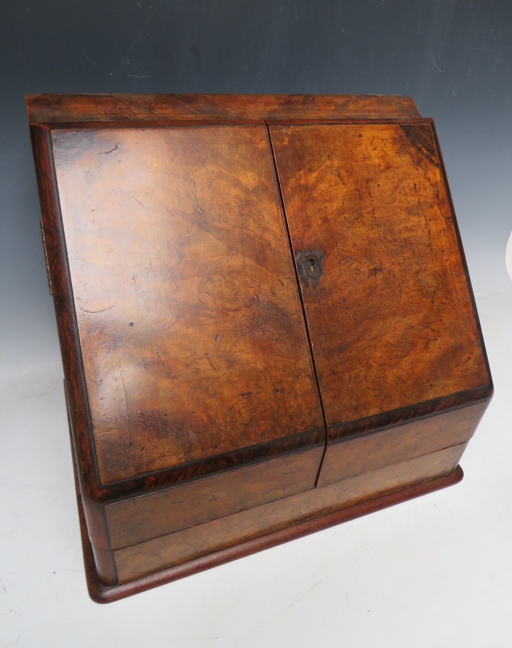 A LATE 19TH CENTURY WALNUT STATIONARY BOX, having hinged twin doors opening to a fitted interior,