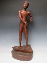 A VINTAGE CARVED HARDWOOD STUDY OF A FISHERMAN, stood on the prow of a boat, H 71 cm