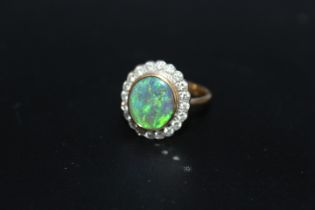 A HALLMARKED 18 CARAT GOLD OPAL AND DIAMOND RING, the central oval opal being of an estimated 2.33