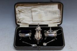 A CASED HALLMARKED SILVER THREE PIECE CRUET SET - BIRMINGHAM 1928, together with two spoons, W 20.