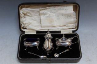 A CASED HALLMARKED SILVER THREE PIECE CRUET SET - BIRMINGHAM 1928, together with two spoons, W 20.