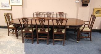 AN ANTIQUE MAHOGANY WIND-OUT DINING TABLE AND THREE LEAVES AND EIGHT CHAIRS, the table raised on