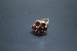 A HALLMARKED 9 CARAT GOLD SEVEN STONE GARNET DRESS RING, approx weight 3.73g, ring size N