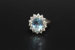A HALLMARKED 18 CARAT WHITE GOLD AQUAMARINE AND DIAMOND CLUSTER RING, the central Aquamarine being