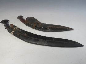 TWO VINTAGE KUKRI DAGGERS, both with two smaller daggers, smaller L 45 cm, blade L 33 cm, larger L