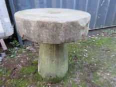 AN ANTIQUE SANDSTONE MILL STONE ON STAND, H 73 cm