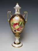 A SPODE HAND PAINTED TWIN HANDLED VASE AND COVER SIGNED 'KEN YATES'. decorated with fruit, H 31.5