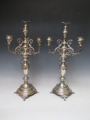 A PAIR OF UNMARKED WHITE METAL CANDLESTICKS, having central twin handled urn design central column