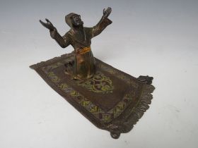 A VINTAGE AUSTRIAN COLD PAINTED BRONZE OF AN ARAB ON A PRAYER MAT, H 9 cm, W 10 cm, L 18 cm