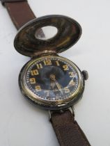 A WW1 SILVER CASED HALF HUNTER TRENCH WRISTWATCH, with leather strap, visible dial Dia. .75 cm, case