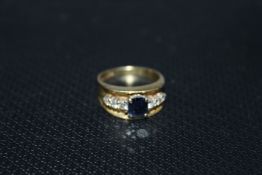 AN UNUSUAL HALLMARKED 18 CARAT GOLD SAPPHIRE AND DIAMOND RING, set in a textured channel style