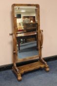 A MID VICTORIAN FULL - LENGTH CHEVAL MIRROR, held on scrolling supports and feet, H 169 cm, W 88