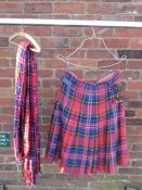 A TARTAN MILITARY KILT TOGETHER WITH A TARTAN PIPERS PLAID