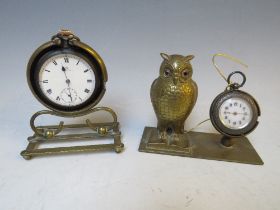 AN OMEGA POCKET WATCH HELD IN A BRASS HOLDER, with an owl fob watch holder and .935 fob watch (2)