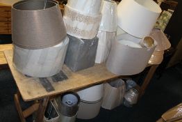 A LARGE QUANTITY OF ASSORTED LAMP / LIGHT SHADES - ( ON AND UNDER TABLE )