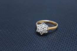 A HALLMARKED 18 CARAT GOLD DIAMOND 'DAISY' RING, set with seven diamonds totalling an estimated 0.33