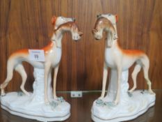 A PAIR OF 19TH CENTURY STAFFORDSHIRE GREYHOUNDS WITH HARE IN THEIR MOUTHS A/F