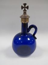AN ANTIQUE BLUE GLASS BOTTLE WITH HANDLE HAVING HALLMARKED SILVER BOTTLE STOPPER IN THE FORM OF A