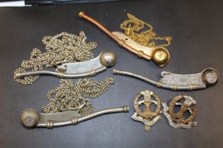 A COLLECTION OF FOUR ASSORTED BOSUN WHISTLES ON CHAINS TOGETHER WITH TWO MILITARY BADGES