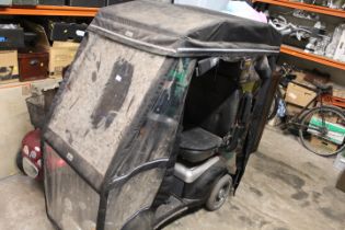 A SHOP RIDER MOBILITY SCOOTER WITH RAIN CLOAK