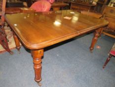 A LATE VICTORIAN MAHOGANY WIND-OUT DINING TABLE WITH ONE SPARE LEAF RAISED ON FLUTED SUPPORTS - L